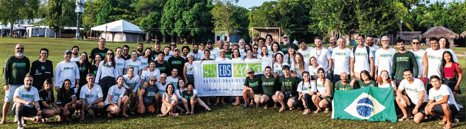 Voluntários da EDS reunidos com a bandeira do Brasil