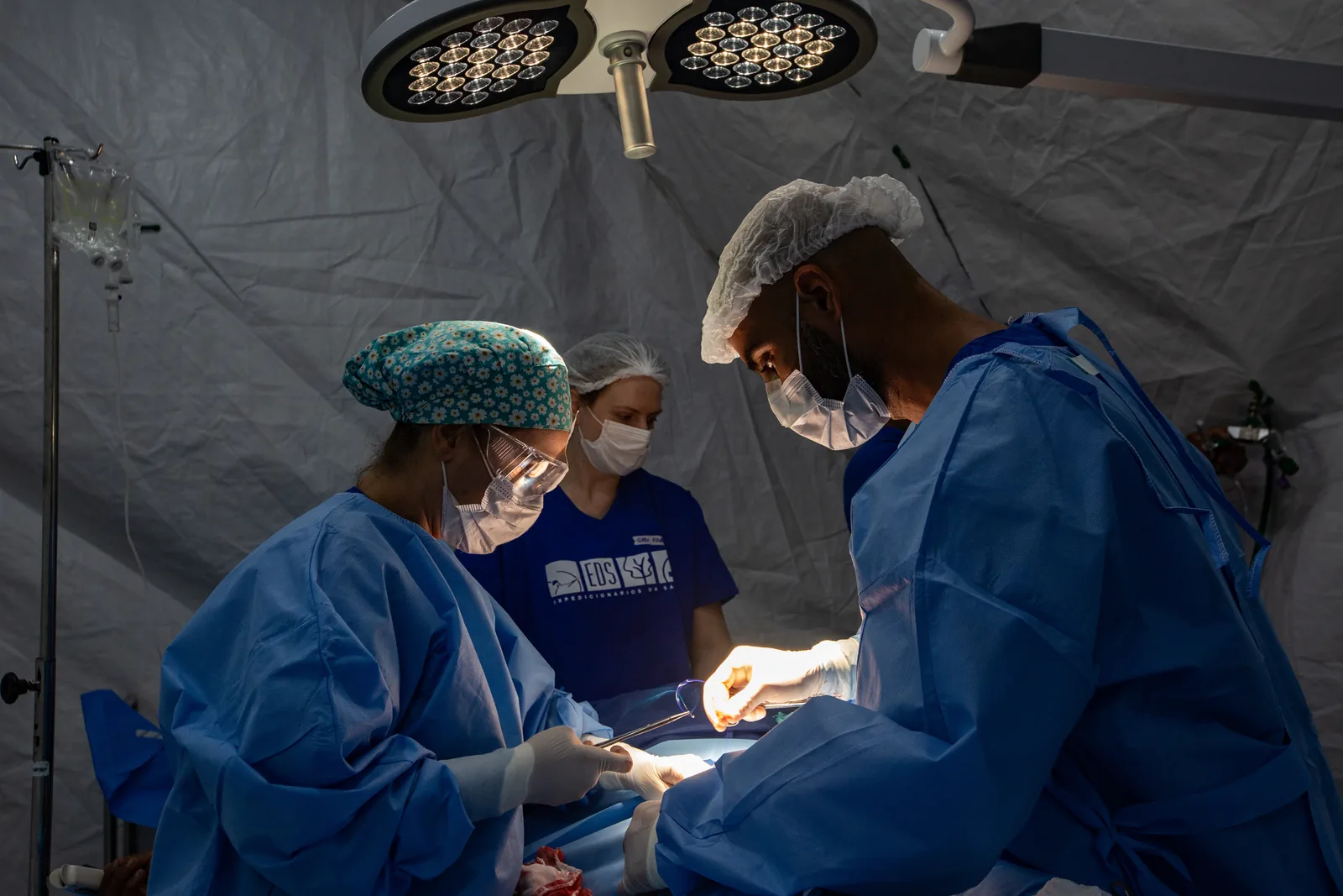 Cirurgiões sob o foco cirúrgico no hospital móvel