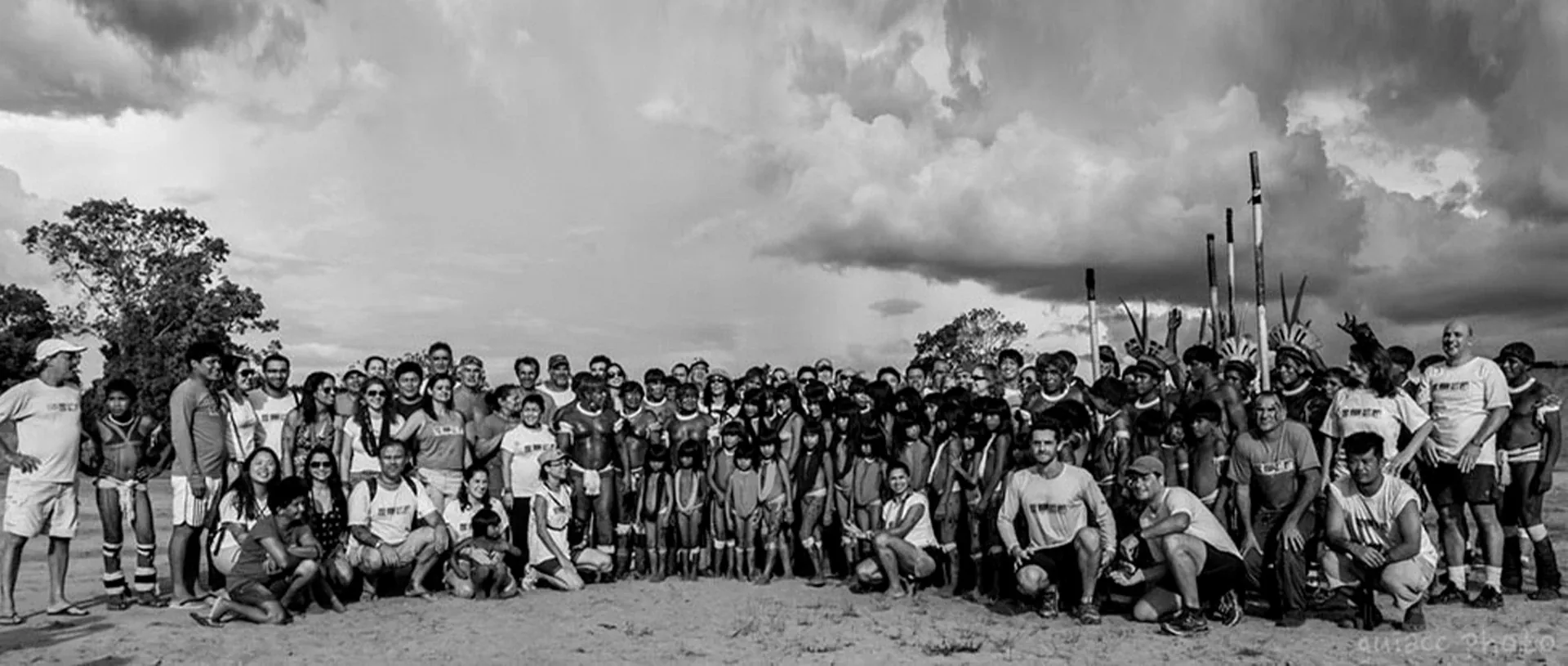 Foto em preto e branco de voluntários e comunidade reunidos em uma expedição