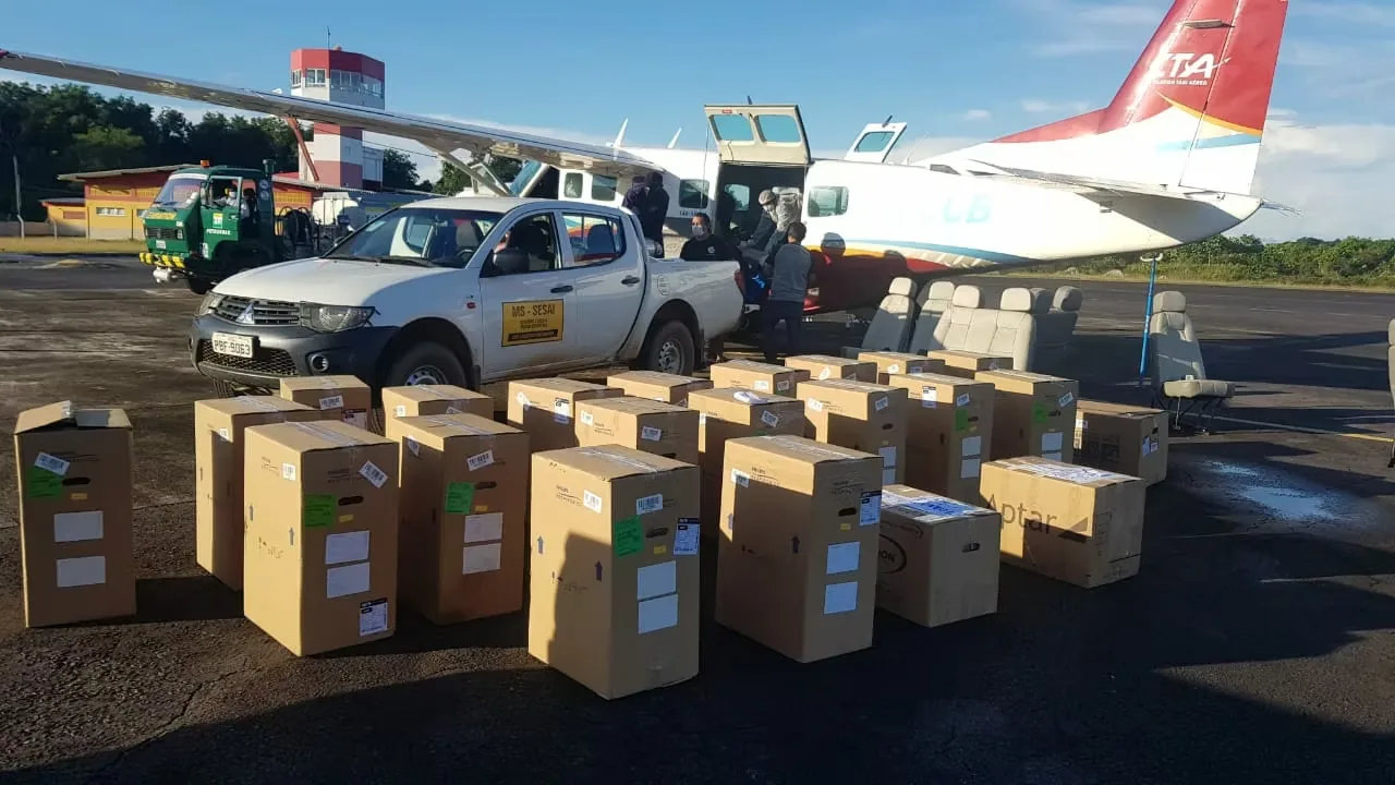 Caixas de insumos ao lado de avião em pista de pouso na Amazônia